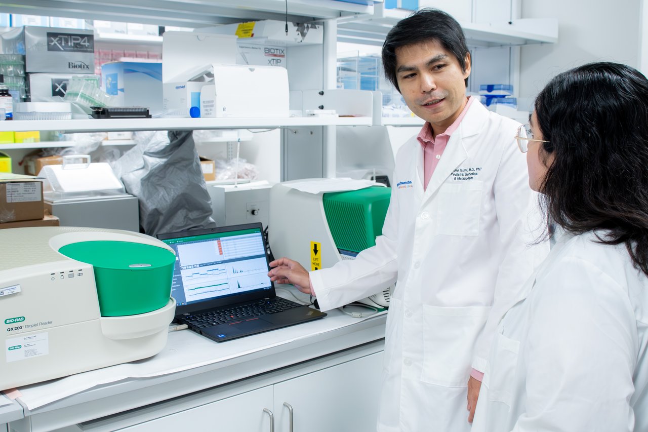 Dr. Izumi showing a lab member data on a computer