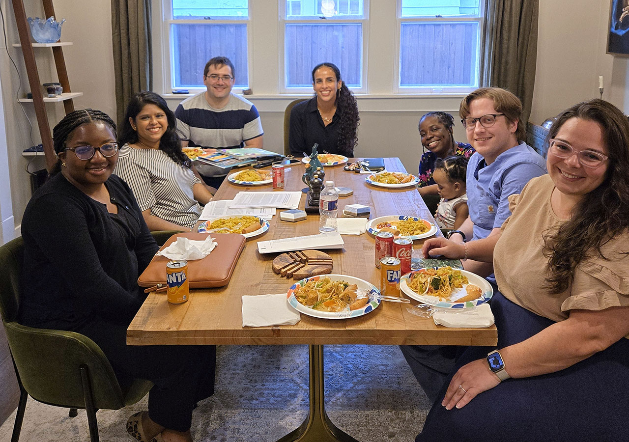 A group shot of the Fellows eating at a table