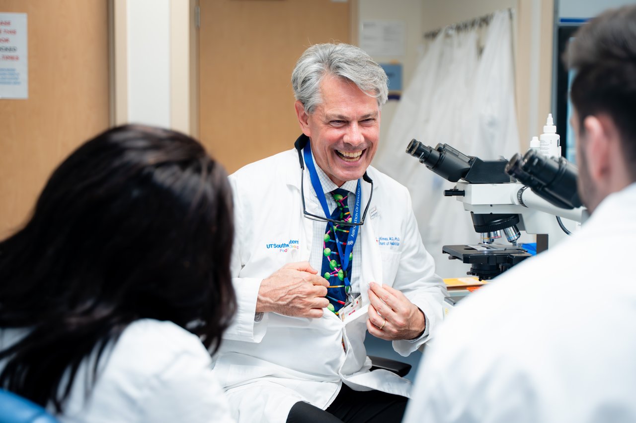 Dr. McKinney pointing at his tie and smiling