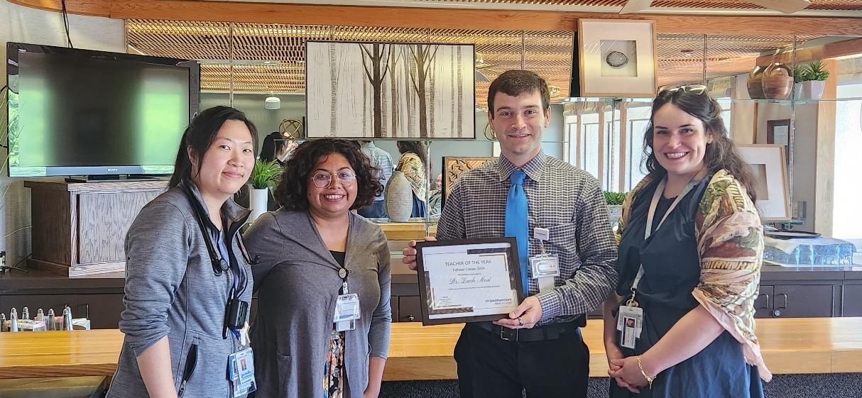 Pediatric Infectious Disease Fellowship group photo, when one member holding a Teacher of the Year award