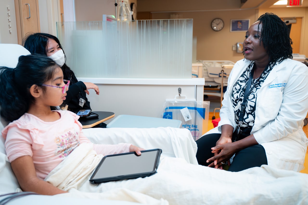 Dr. Petgrave speaking to a patient holding an iPad