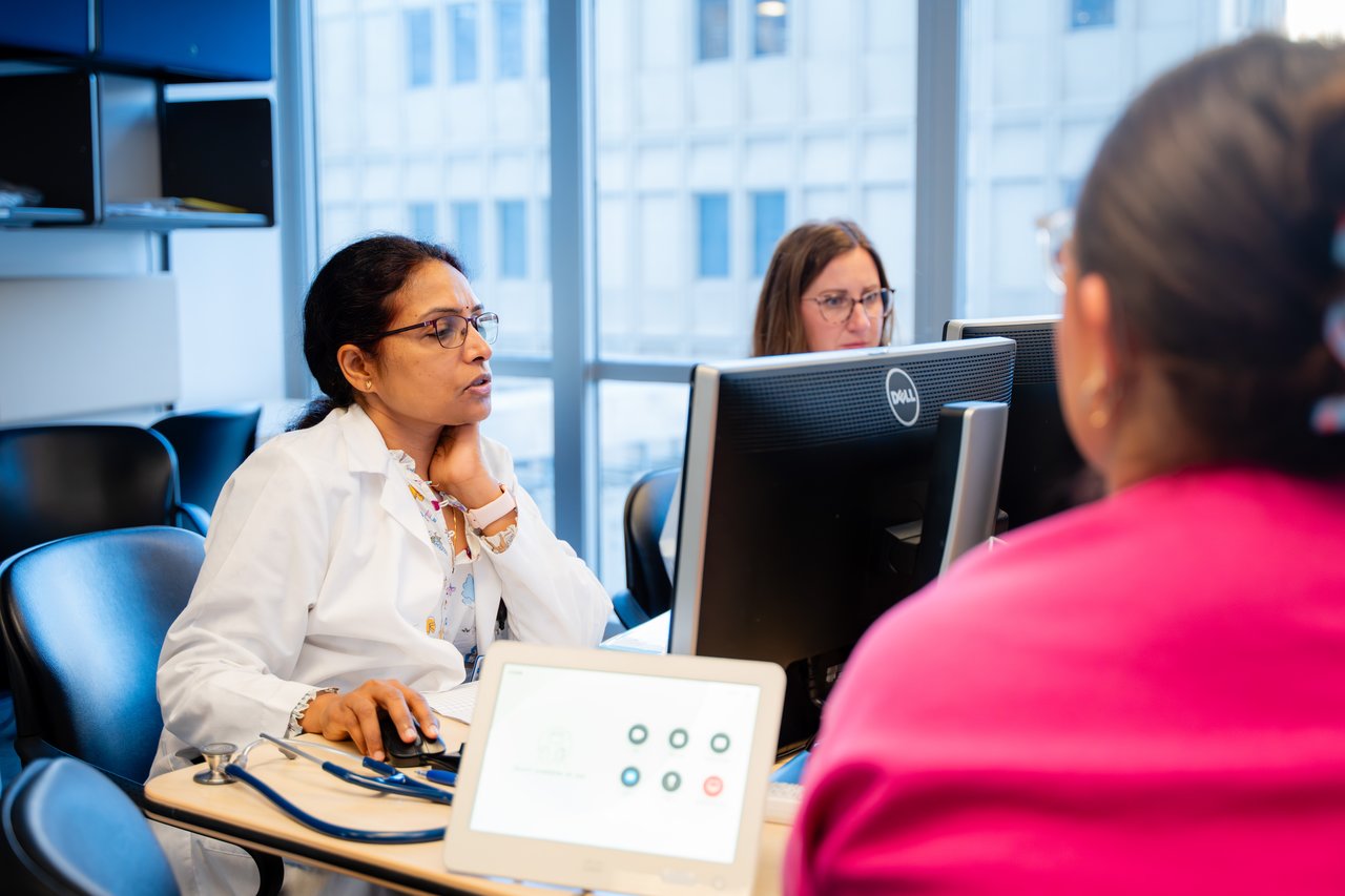 Dr. Gattineni on her computer, doing rounds with residents