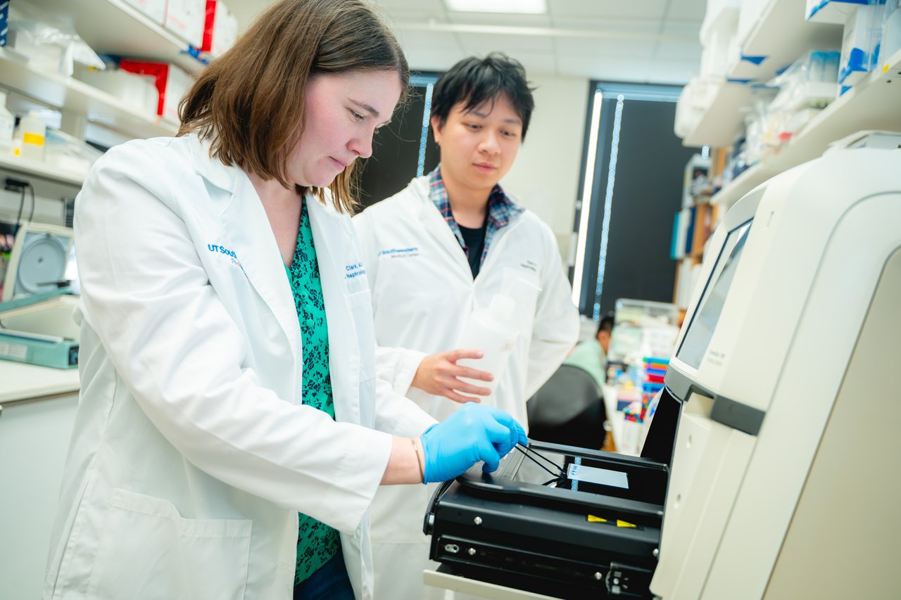 Dr. Clark with a lab member inspecting lab equipment