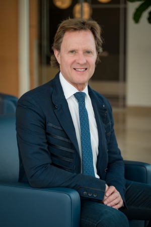 Dr. Jeffrey Kenkel, Chair, Department of Plastic Surgery in blue suit seated in blue leather chair