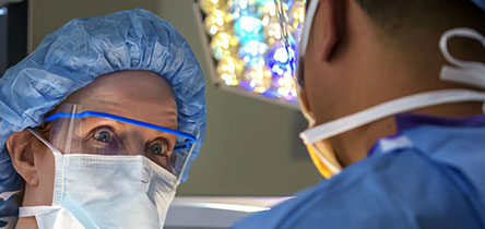 two surgeons donning masks