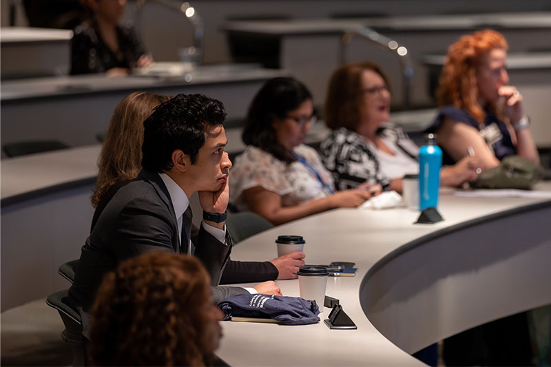 Ballroom of tables with people looking at a presentation that says Pelvic Ring nonunion