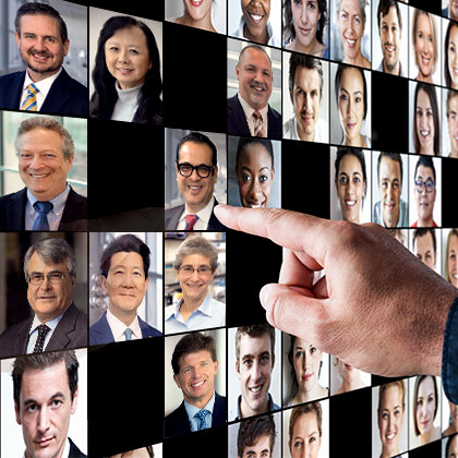 A person points at a wall covered with photos of peoples faces