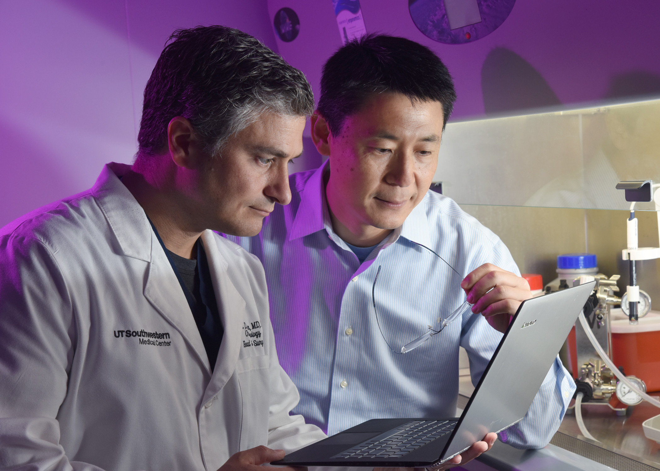Two doctors reviewing data on a laptop