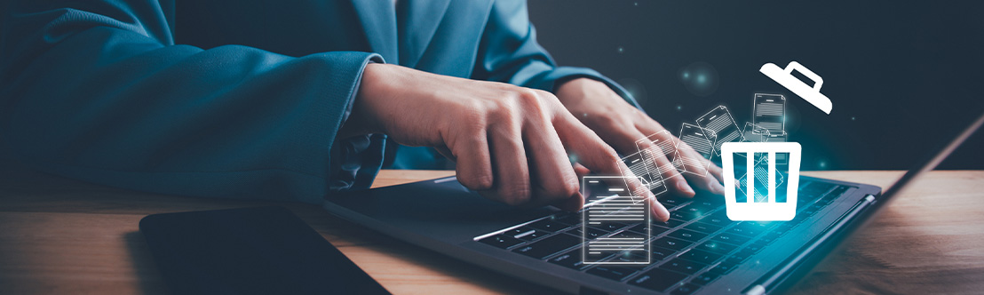 A stylized illustration of a person typing on a laptop as floating document icons flow into a trash icon