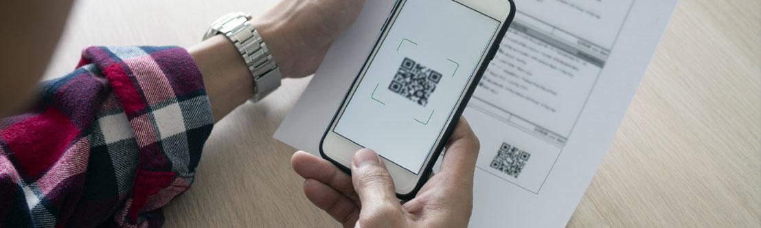 A close-up photo of a person scanning a QR code with their phone