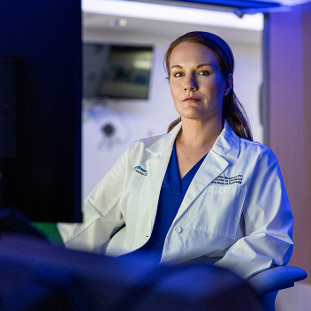 Dr. Davenport posing in a lab, wearing her white coat