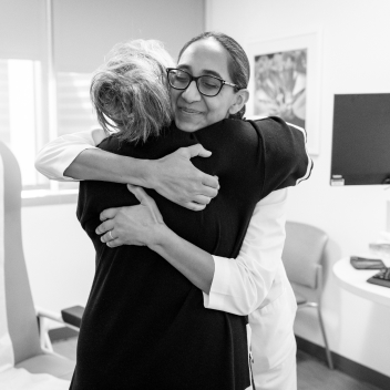 Dr. Patel hugging a female patient, offering support