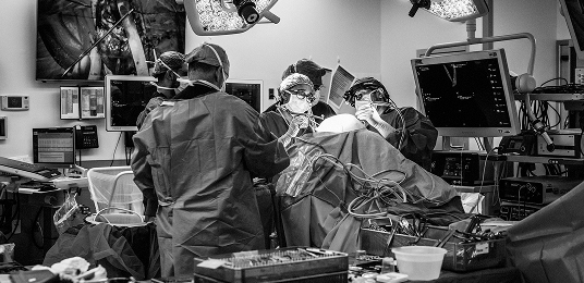 A black and white photo of medical professionals in the operating room.