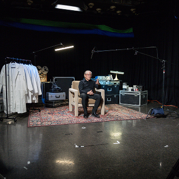 Dr. Takahashi sitting down in a chair, getting interviewed
