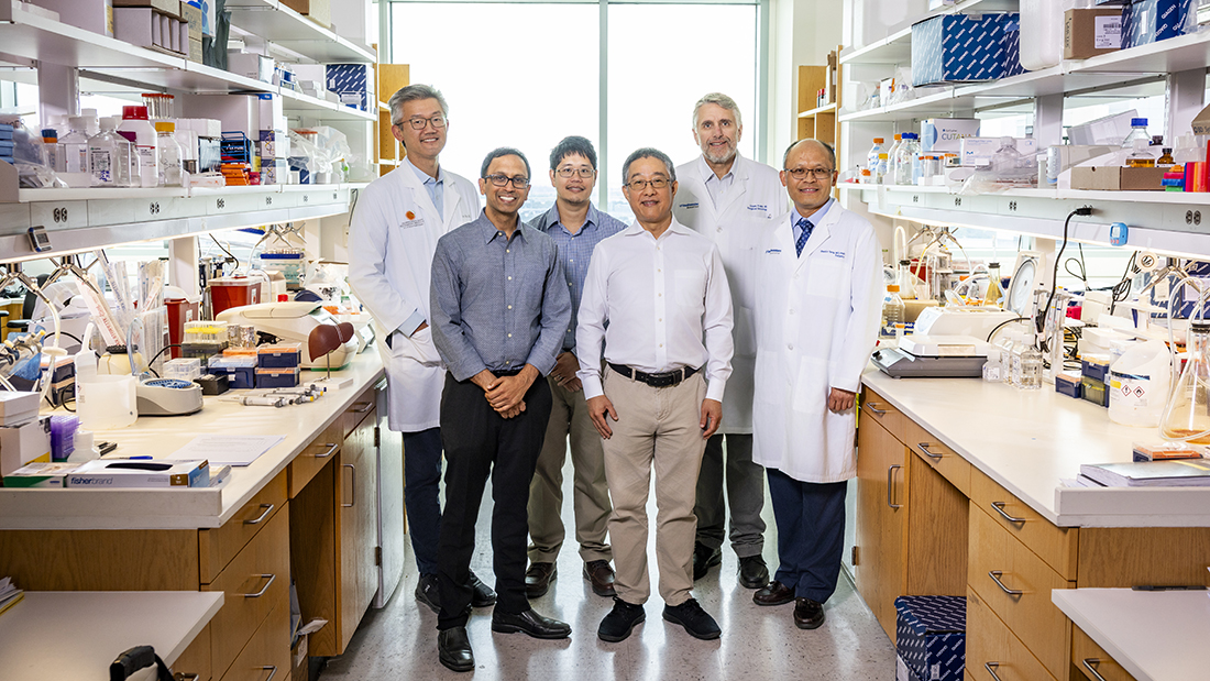 Group of men posing for the camera in a lab setting