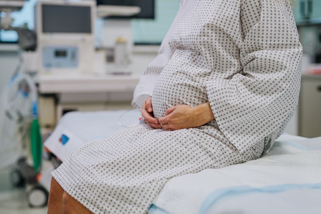 Pregnant woman in labour waiting for examination in maternity ward.