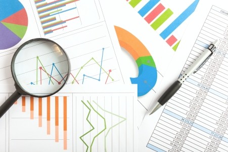 colorful charts and line graphs on paper with pen laying on top